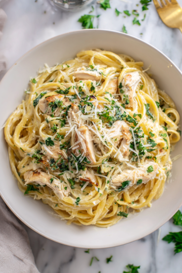 Creamy Chicken Alfredo pasta with fettuccine, golden chicken, and herbs in a delicious sauce.