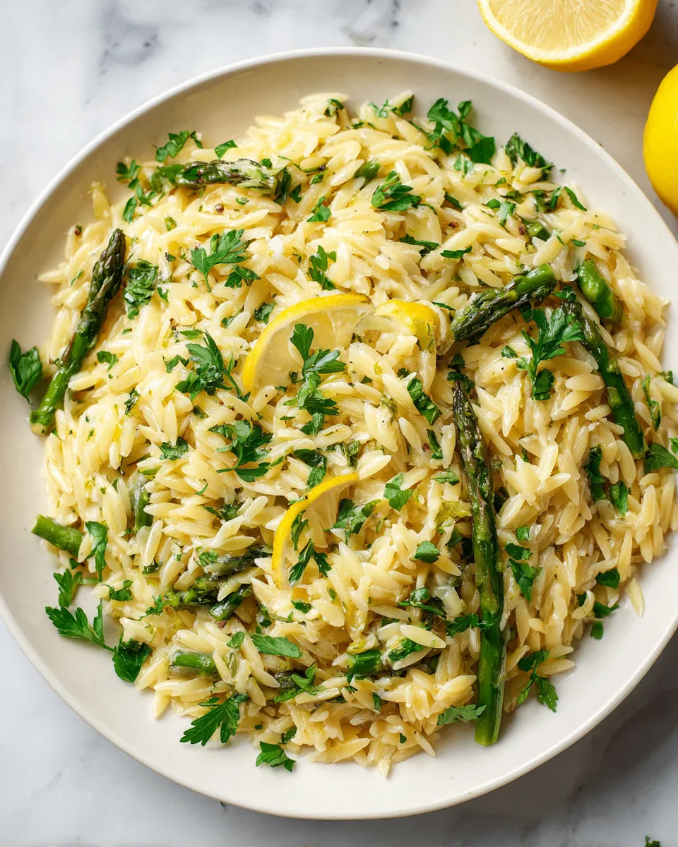 Lemon Parmesan Garlic Orzo with Asparagus dish garnished with parsley, featuring vibrant colors and zesty flavors, ideal for holiday meals.