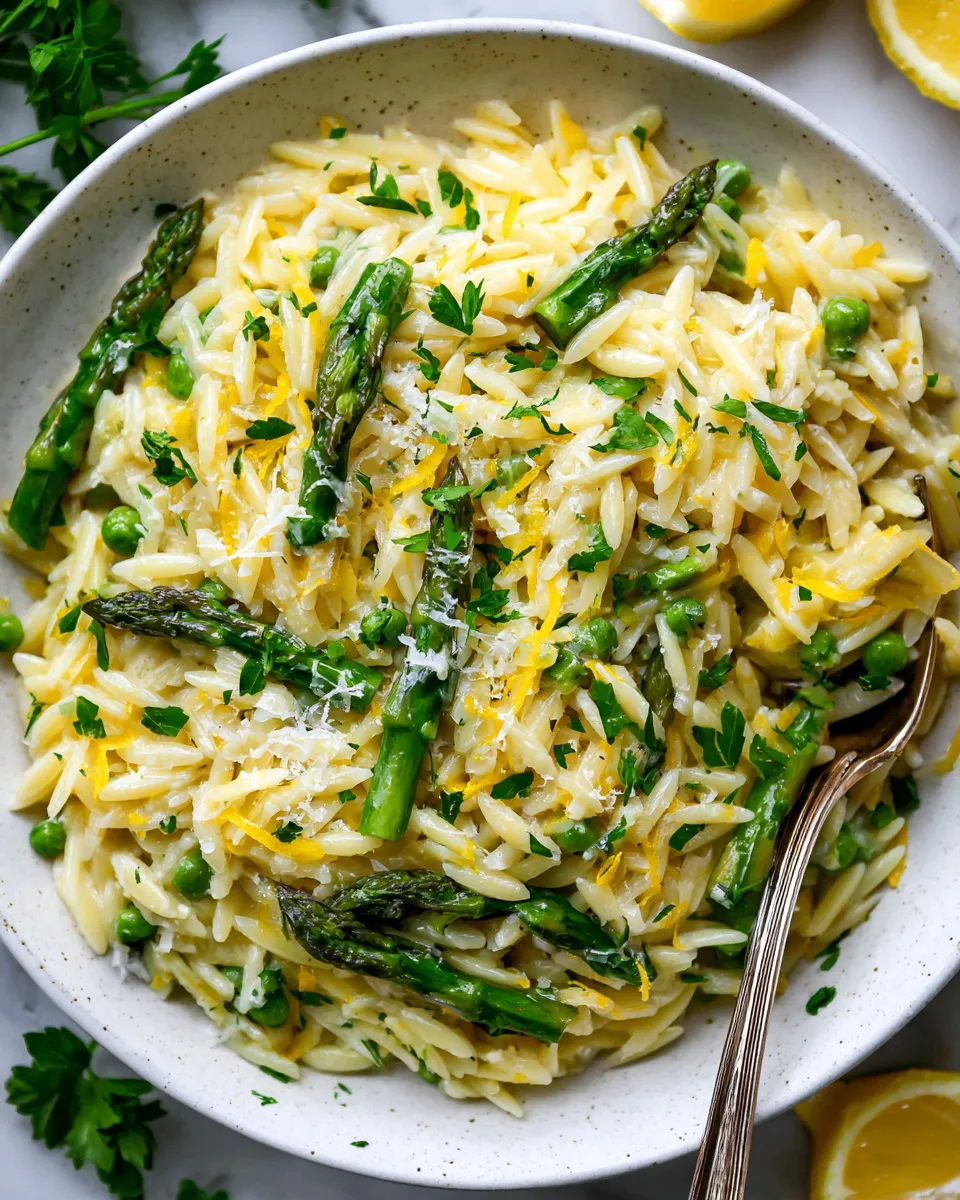 Lemon Parmesan Garlic Orzo with Asparagus dish garnished with parsley, featuring vibrant colors and zesty flavors, ideal for holiday meals.